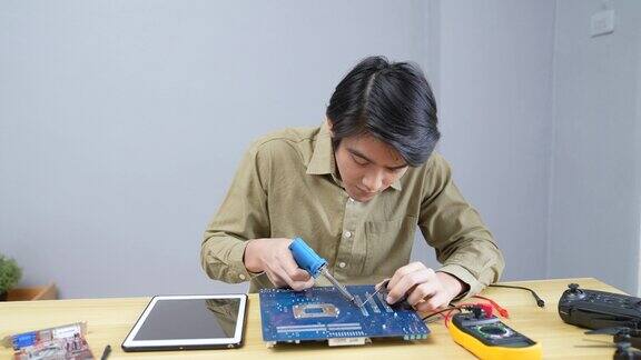 一名亚洲男子在家检查电子设备
