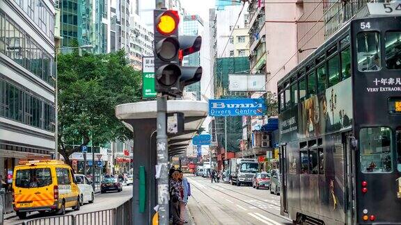 香港市中心人们在电车站等待铁轨的4K时间间隔人们在过马路