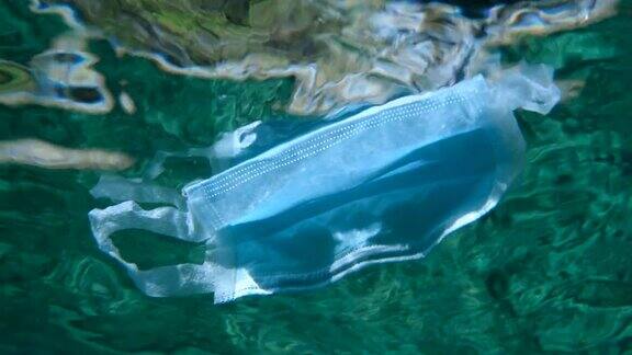 废弃的医用口罩在水面下缓慢漂浮新冠肺炎正在加剧污染废弃的口罩和塑料垃圾一起污染海洋
