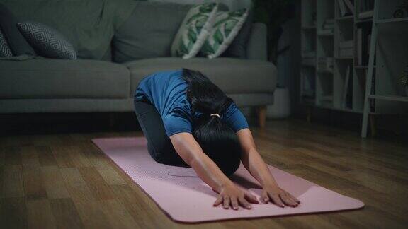 年轻的单身女性在地板上做伸展瑜伽练习