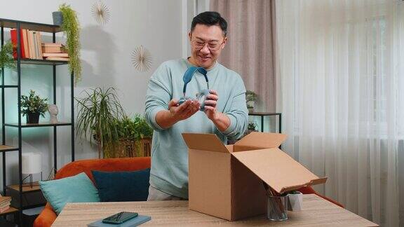 开心的中国男购物者打开纸箱快递包裹网购在家购买