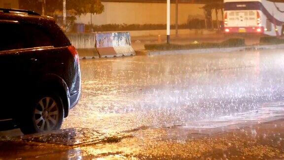 热带降雨在夜间的道路在亚洲汽车在大雨下站立和行驶泰国