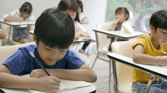 学生在笔记本上写字在教室里考试