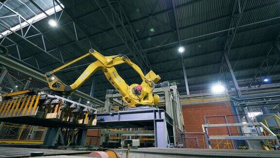 机械机械臂正在工厂里搬运砖块