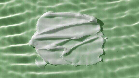 白色身体霜涂抹在绿色背景下荡漾的水