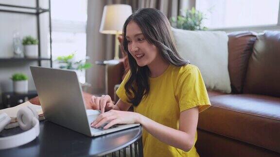 年轻迷人的亚洲女性在家里工作用手提电脑检查业务数据图表规划报告休闲放松在客厅沙发上居家隔离