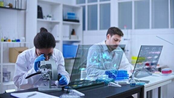 黑人女科学家在实验室显微镜下检查样品物质