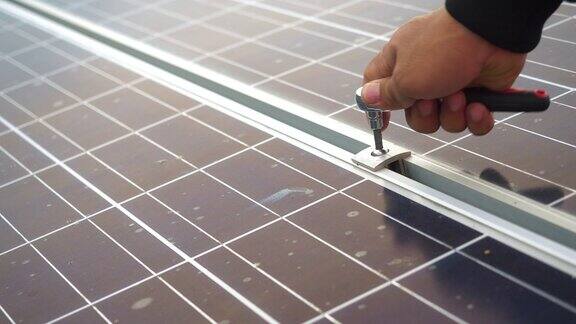 电工在室外安装太阳能电池板系统的特写