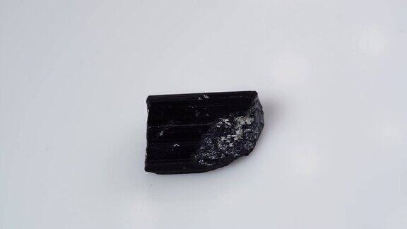 黑色电气石谢勒粗样品在白色背景的转盘上