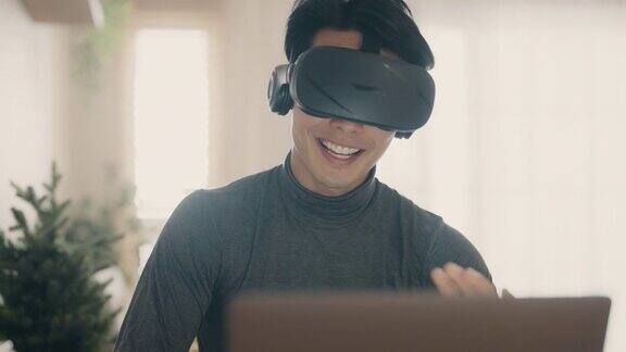 亚洲男人在家带着VR眼镜工作