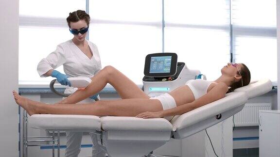 美容师在病人的腿上做激光脱毛手术