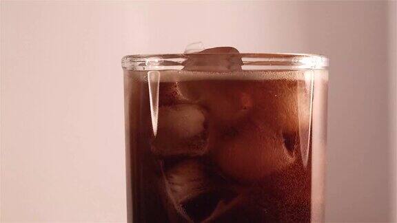 将冰凉的可乐倒入玻璃杯中
