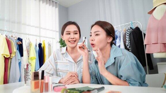 两位美丽的亚洲年轻女性在博客上录制了在眉毛上涂眉笔后的妆容并在网上出售美丽的网红在社交媒体上推广他们的眉笔产品直播待售
