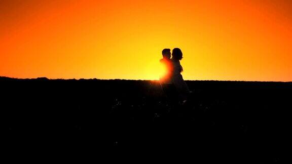 恋爱中的男人和女人在日落时跑向对方拥抱