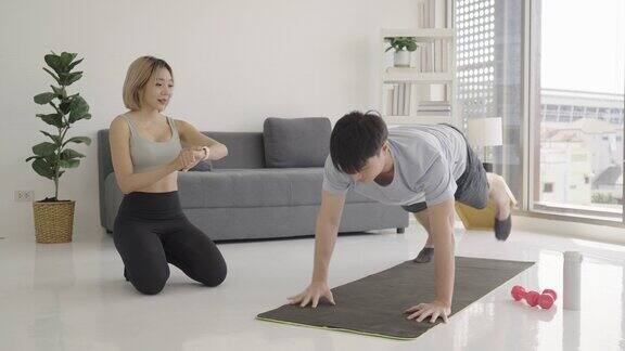 一个女人在私人教练的指导下在家锻炼的画像