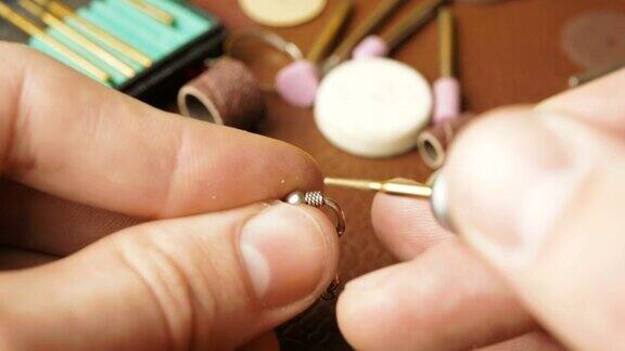 专业的珠宝商用一种特殊的工具抛光银质耳环一位专业雕刻师制作一件珠宝