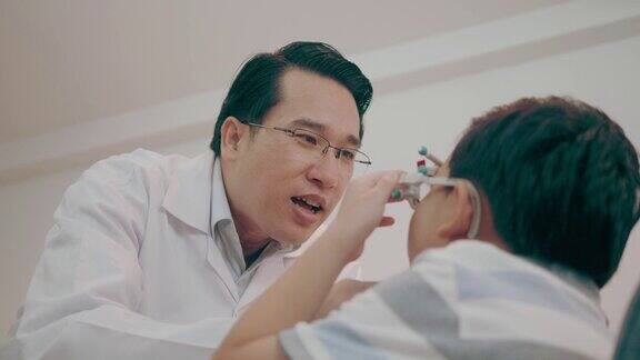 眼科医生检查男孩眼睛与试验框架-股票视频
