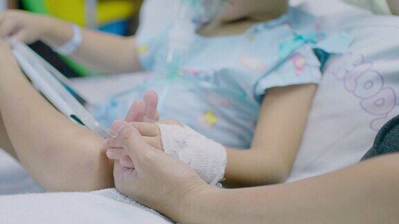 (特写)医院病床上父亲牵着熟睡的儿子的手