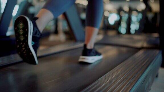 在健身房跑步机上跑步的女人的腿