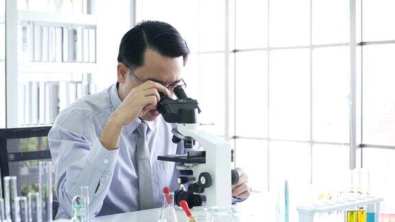 侧视图:医学研究人员在光学显微镜上进行实验