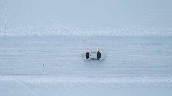 一辆白色汽车在雪路上行驶的鸟瞰图