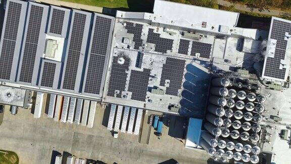 太阳能发电厂鸟瞰图蓝色光伏板安装在工业建筑屋顶生产绿色生态电力生产可持续能源