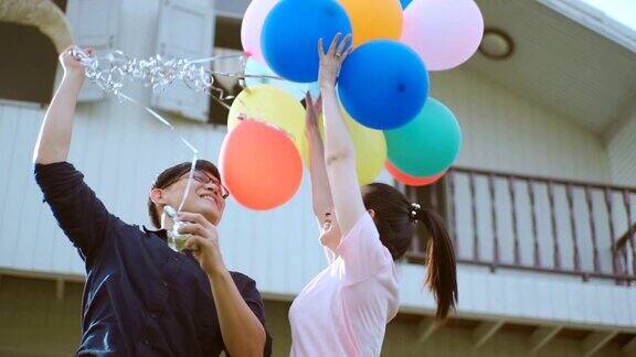 无忧无虑的夫妇在花园房子玩气球慢动作