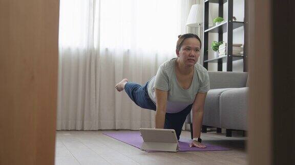 亚洲妇女在家做普拉提和瑜伽锻炼