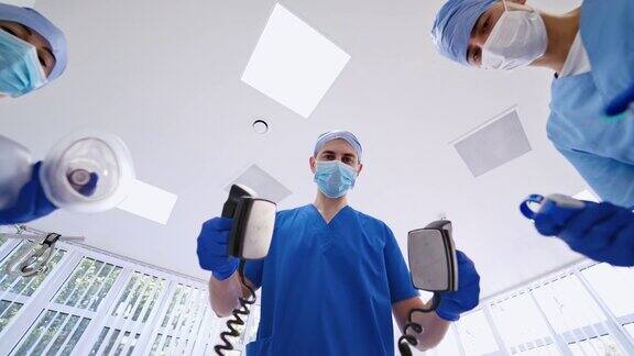 三个医生拿着医疗器械在急诊室里