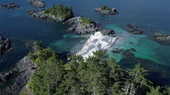 无人机拍摄的人们站在海湾岛屿附近的大陆桥上