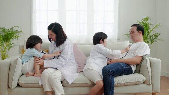 亚洲家庭关系父亲母亲和儿子玩医生和病人在他们的家里