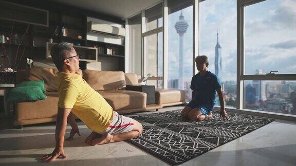 2个亚裔中国老人朋友晚上在公寓客厅享受在家锻炼