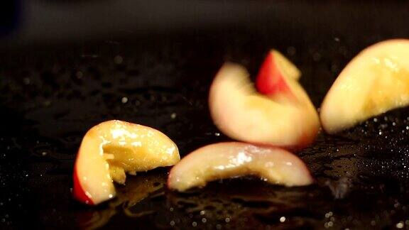 切成薄片的桃子落在潮湿的黑色表面上