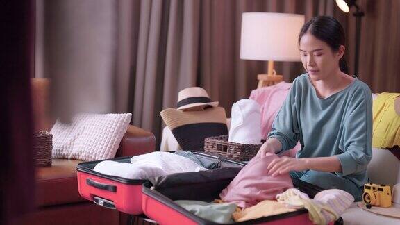 亚洲年轻成熟的成年女性准备旅行亚洲女性穿着休闲布在行李箱和客厅地板上放置打包布以便在封锁结束后旅行