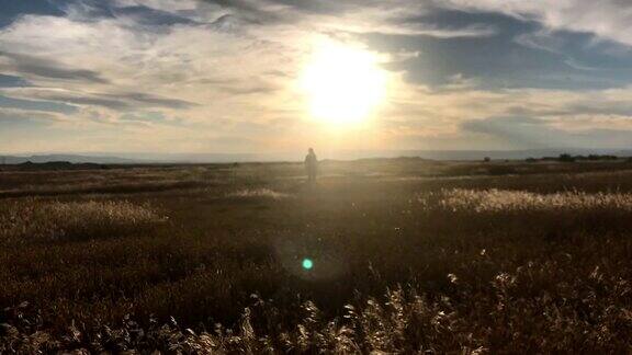 日落时间流逝视频的一个女性行走在沙漠在日落