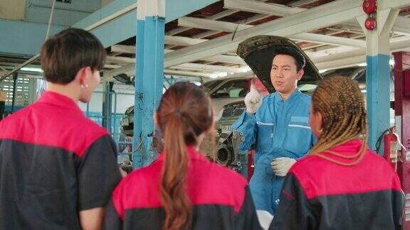 主管工程师正在汽车修理厂教机械工人有关汽车发动机的知识