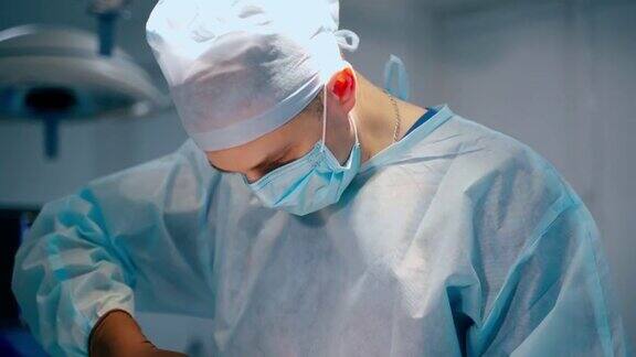外科手术手术室中的手术过程身穿医疗制服、戴着口罩的男医生和女助手在医院做手术