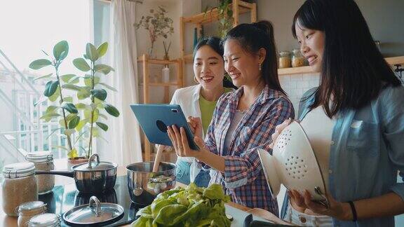 三个快乐的年轻女子在厨房准备亚洲食物