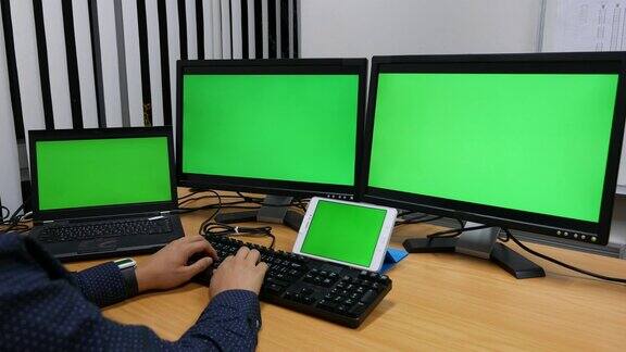 摄影:绿色屏幕的笔记本电脑和显示器