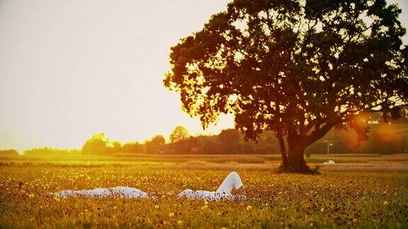 日落时分一对深情的情侣在草地上放松