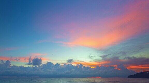 随着时间的推移蔚蓝的天空中明亮的橙色云在日落的海洋之上