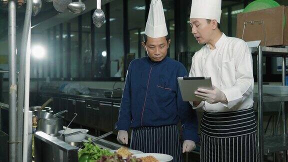 厨师团队准备食物主管在酒店餐厅的厨房检查菜肴食物和丁克概念