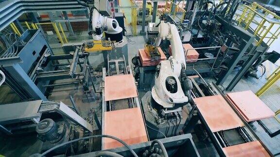 工厂里的机器人正在把铜片堆在一起