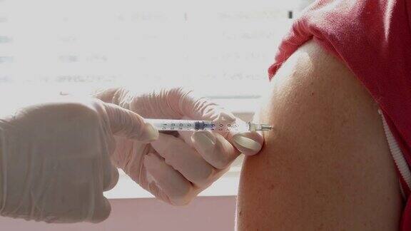 4K视频:医护人员为一个人接种疫苗以预防COVID-19大流行疾病