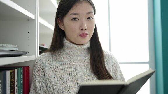 在图书馆大学读书的年轻中国女学生做沉默的手势