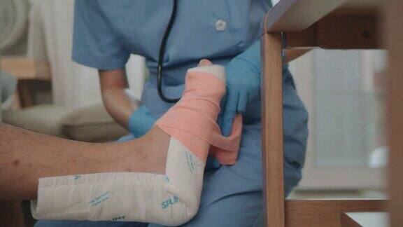 女护士给病人的腿缠上绷带