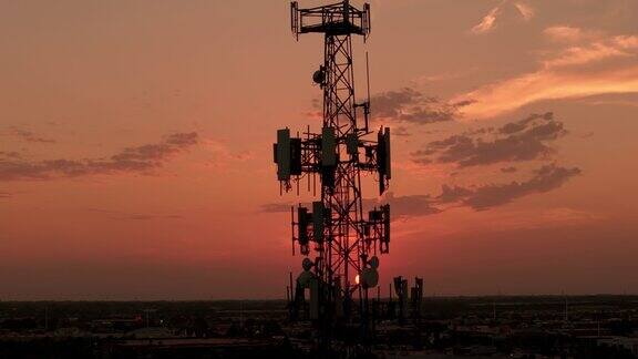 日落时分城市中的电视或无线电话塔航拍变焦照片