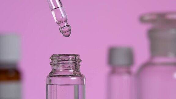 一滴透明的有机精油从吸管中滴落在玻璃瓶中
