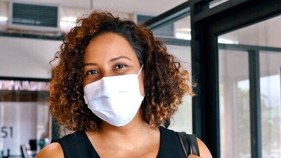 自信的西班牙裔中年妇女在冠状病毒大流行期间戴着防护口罩