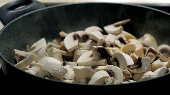 酋长将蘑菇与油和洋葱一起放入锅中慢动作